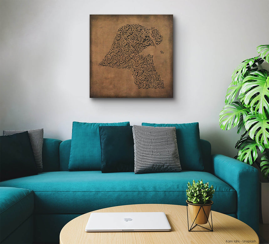 Carved wood artwork of the Kuwait map, drawn in Diwani calligraphy using the names of its cities in a living room setting.