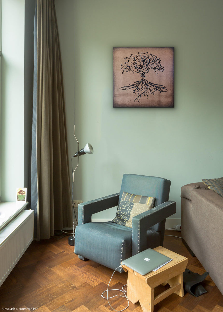 Wooden artwork of an olive tree with the Arabic phrase “The land is ours, and to it we return.” in a living room.