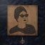 Carved wood portrait of Umm Kulthum with “Enta Omri” lyrics in Diwani Arabic calligraphy.