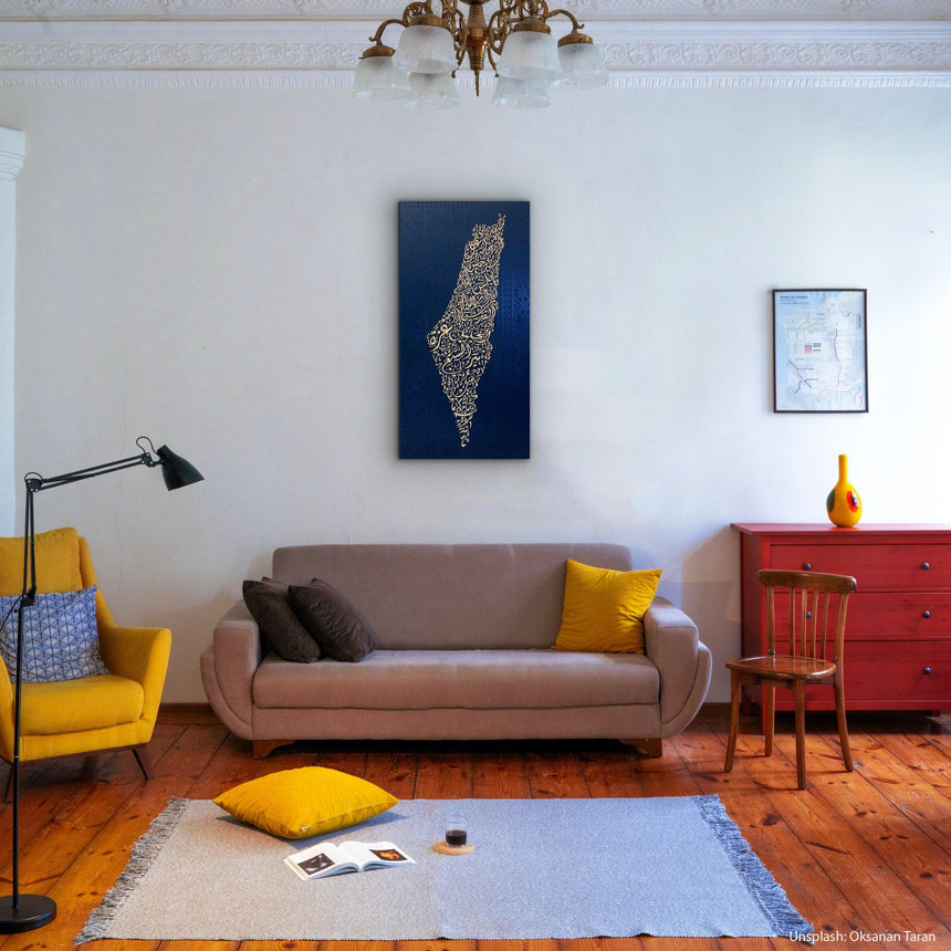 Palestine map in Diwani calligraphy using the names of its cities, with Palestinian tatreez–inspired embroidery in a living room with a beige sofa, yellow armchair, and red dresser.