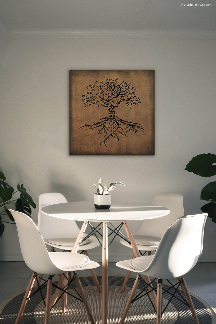 Wooden artwork of an olive tree with the Arabic phrase “The land is ours, and to it we return.” in a living room.
