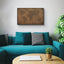 a living room with a blue couch and a map on the wall